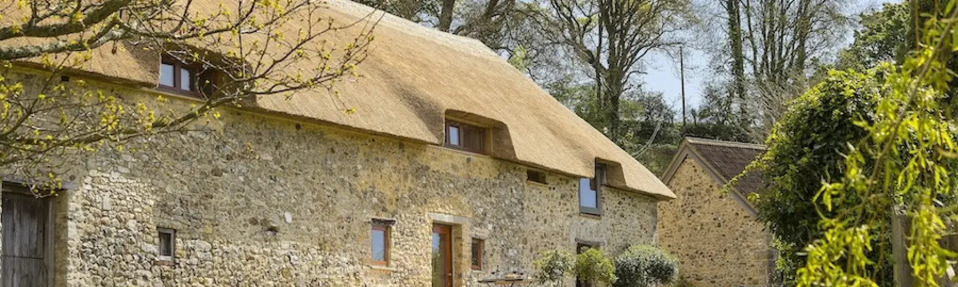 A n ewly thatched Devon cottage overlooking a spacious lawn.