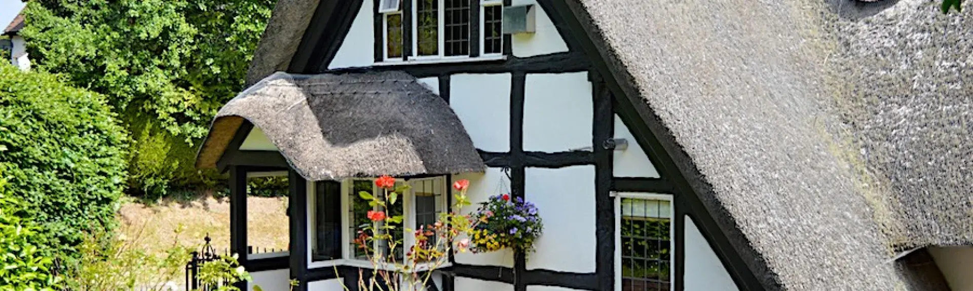 A half-timbered and thatched Tudor Cotswold cottage and garden.