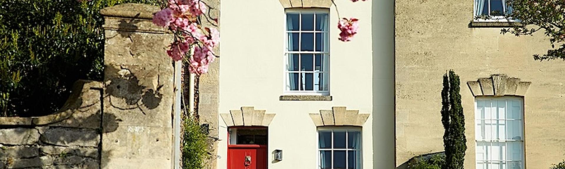 Exterior of a townhouse in Wells with a red front door.