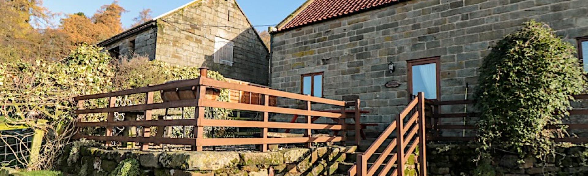 Stone-built, barn conversion exterior with a raised, secure BBQ terrace.