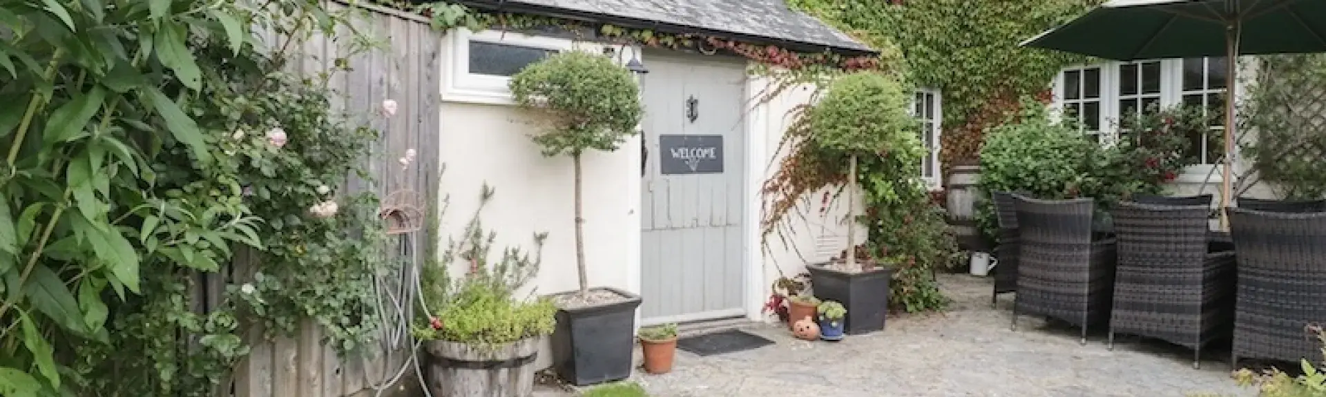 Exterior of a vine-covered Somerset farmhouse.