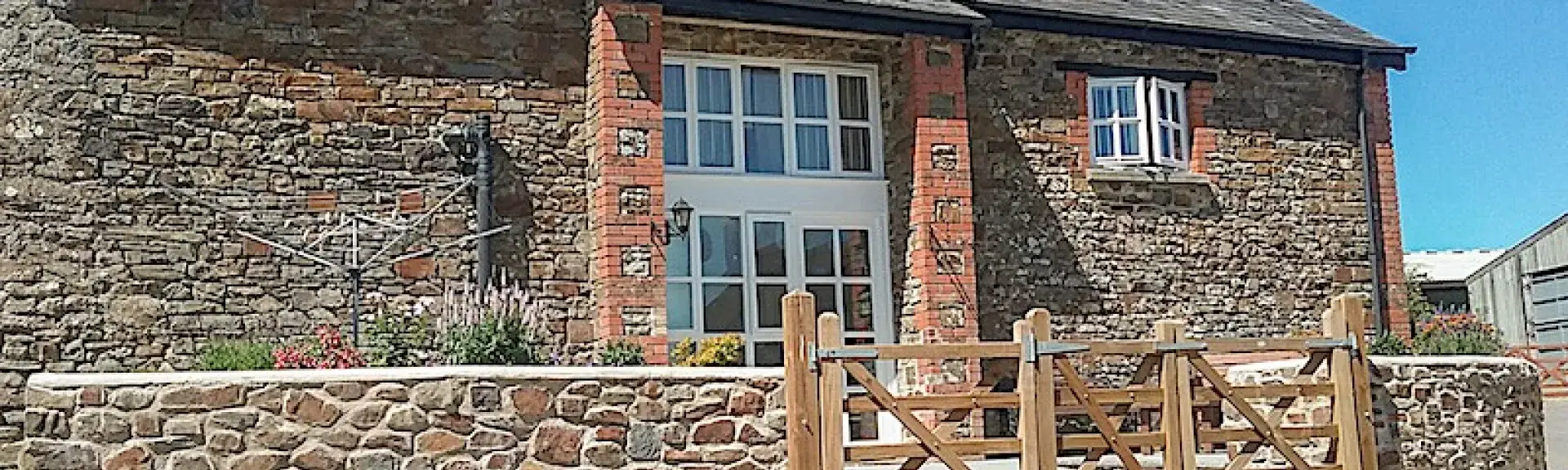 A stone-built North Devon barn conversion overlooks a paved courtyard.