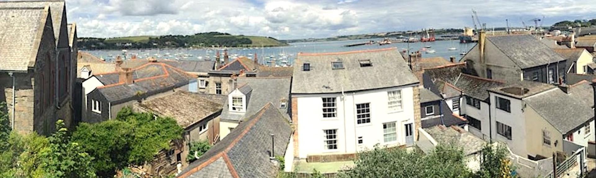 Aerial view of Marine Cottage in Falmouth looking across rooftops towards the sea.