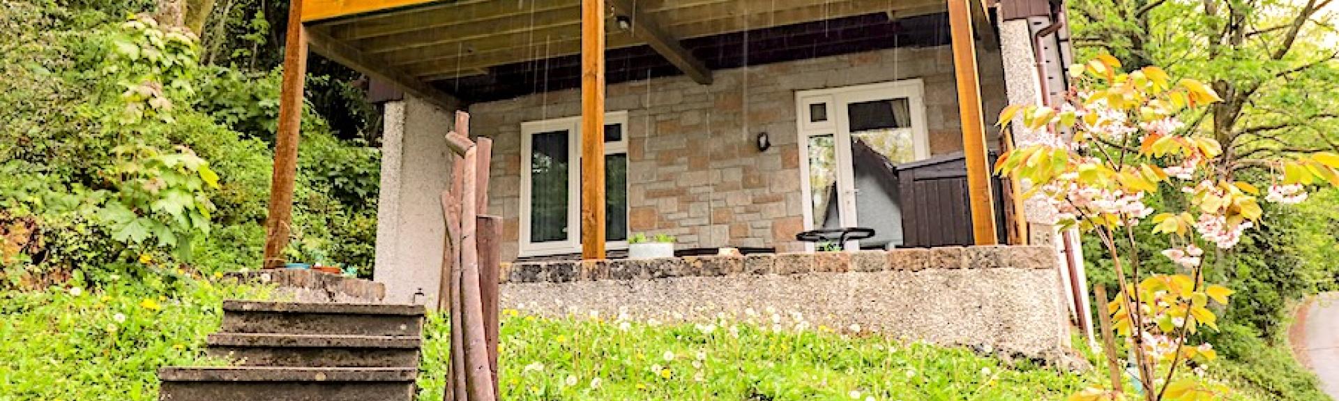 A wood and stone eco lodge with a massive 1st floor balcony enjoys rural views.