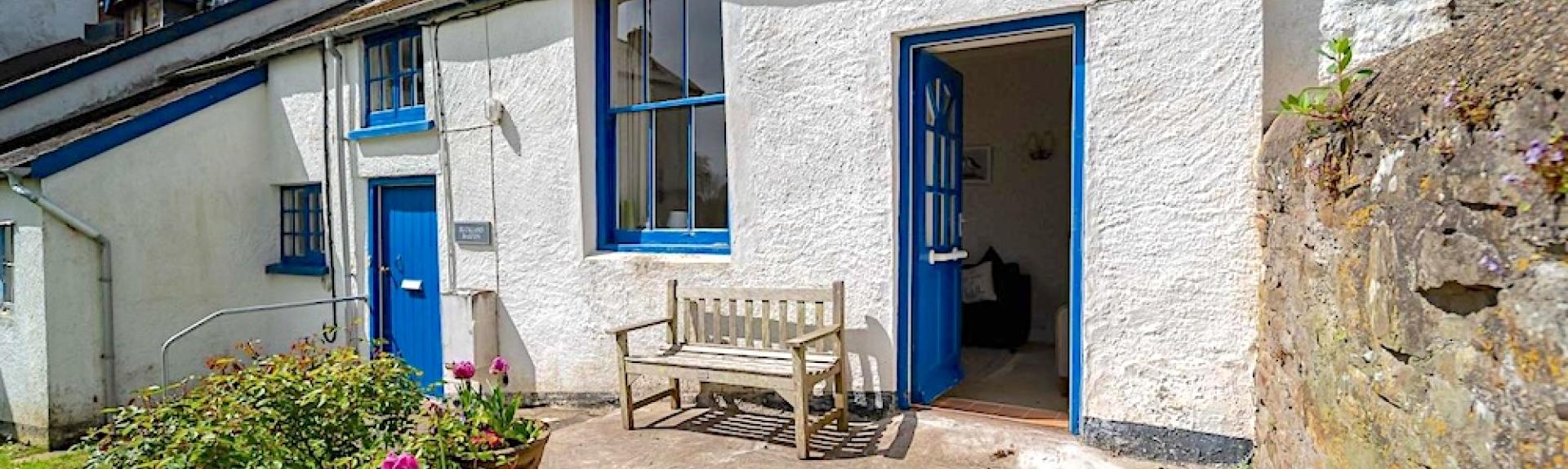 Exterior of a single storey holiday cottage overlooking a courtyard.