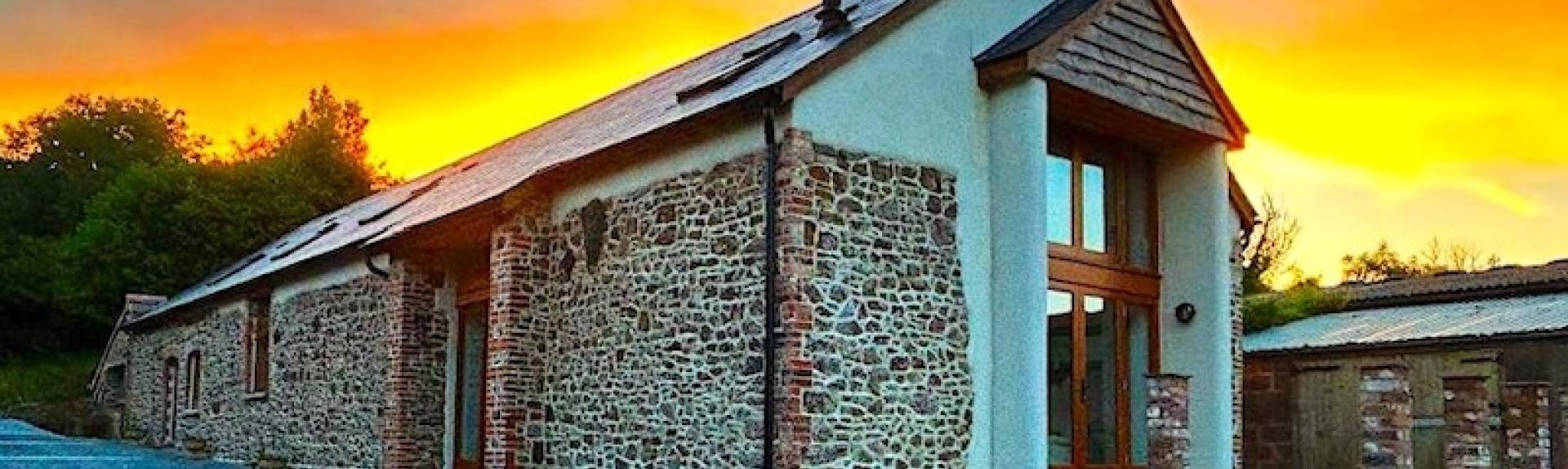 A stone-built Exmoor barn conversion at sunset.