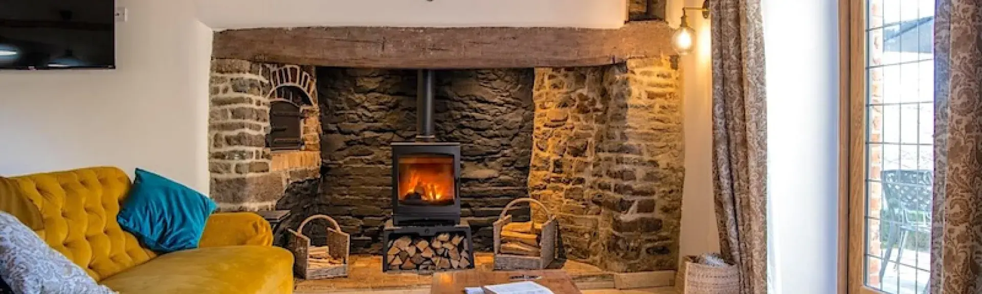 A lounge with twin sofas, inglenook fireplace and French windows.
