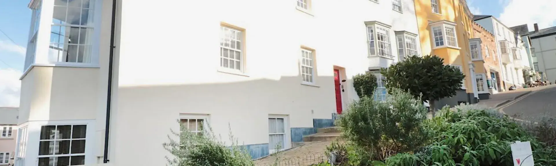 A 3-storey-rendered Herefordshire farmhouse overlooks a block-paved courtyard.