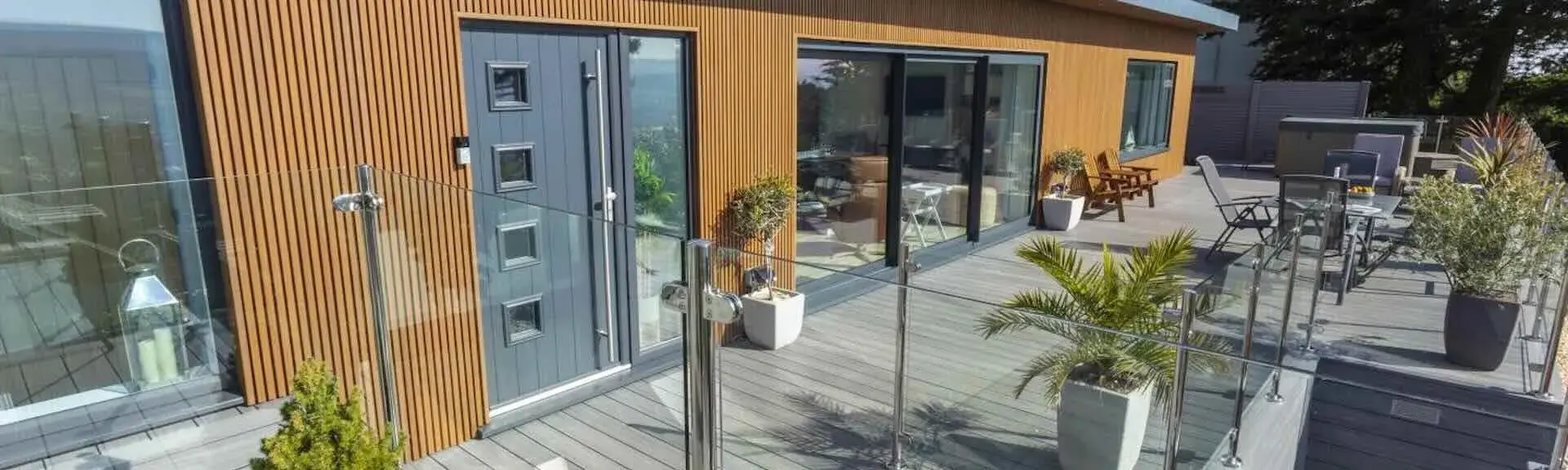 Exterior of a luxury Minehead lodge with bi-fold glass dors and a spacious deck.o
