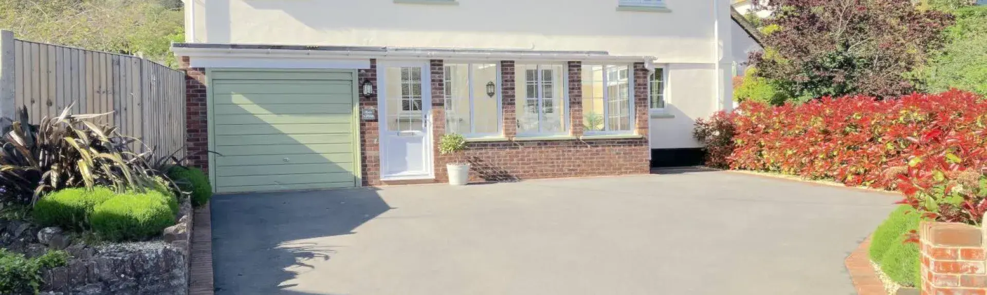 Double-fronted 2-storey Minehead holiday home with large drive and flower-filled borders.