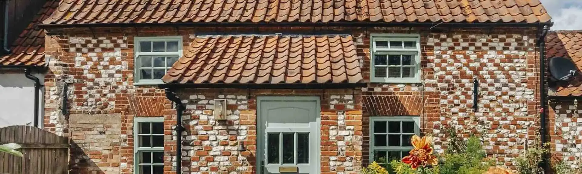 An ornate brick-built detached Kings Lynn holiday cottage overlooking a flower-filled garden. 