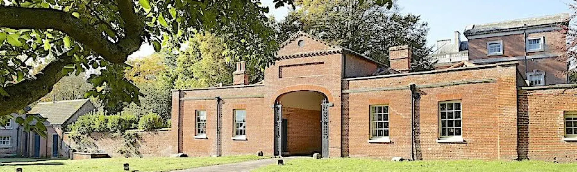 An arched brick gatehouse converted to holiday cottages.