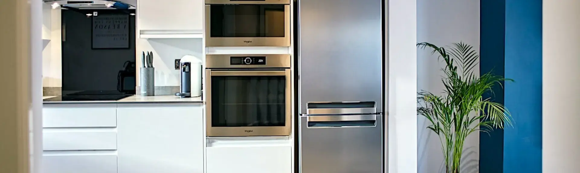 Kitchen with mid-height integrated oven and full-height friidge-freezer.