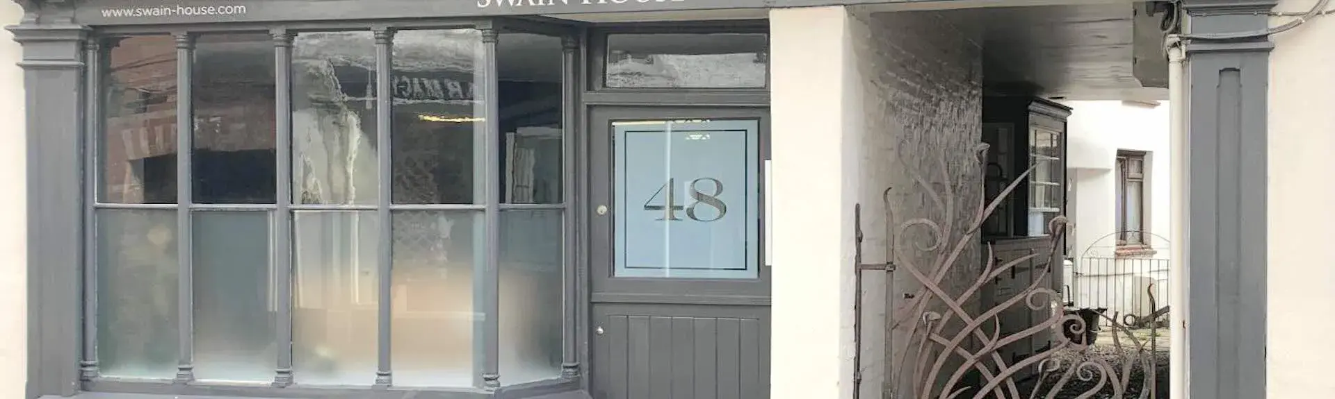 The entrance and front windows of the seaside shop converted into a holiday cottage.