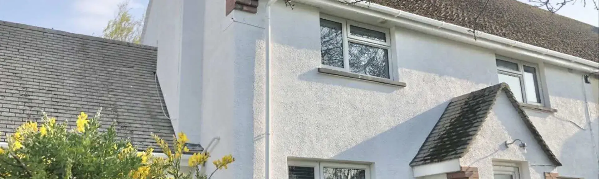 The exterior of a semi-detached, 2-storey Croyde cottage with a covered porch