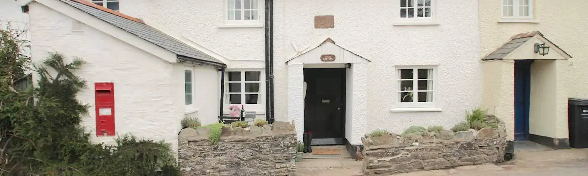Double-fronted cottage exterior overlooks a quiet village street.