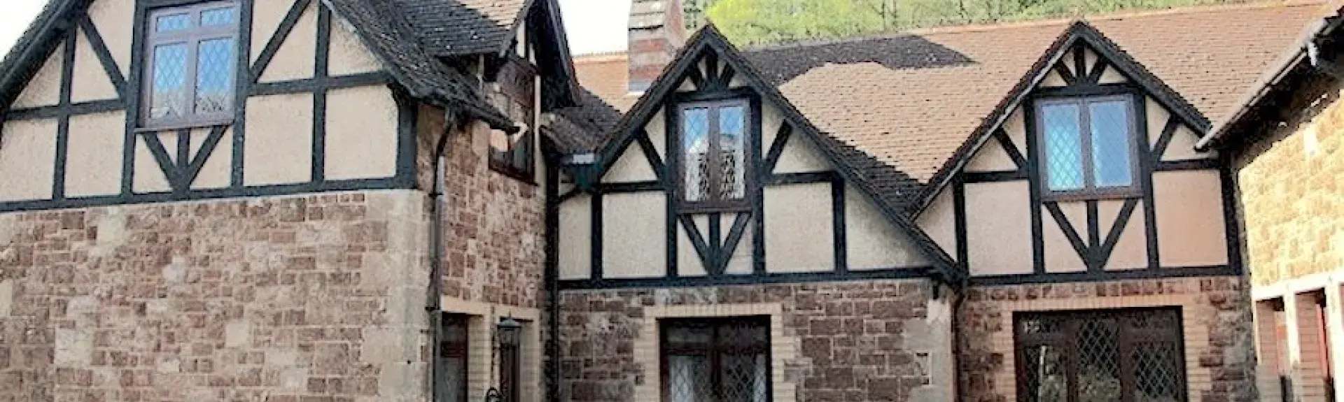 A 2-storey stone-built house overlooks a courtyard.