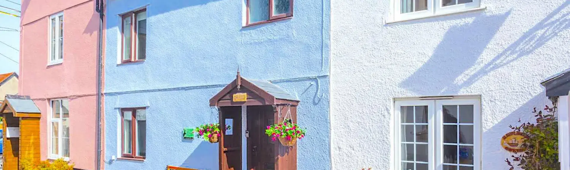 A 2-storey coastal cottage in Watchet with a gabled porch opening onto a village street.