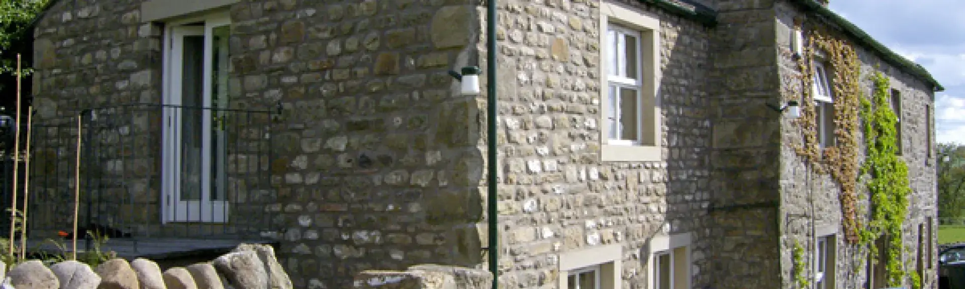 A 2-storey, end-of-terrace stone-built holiday cottage in Settle with a walled side garden.
