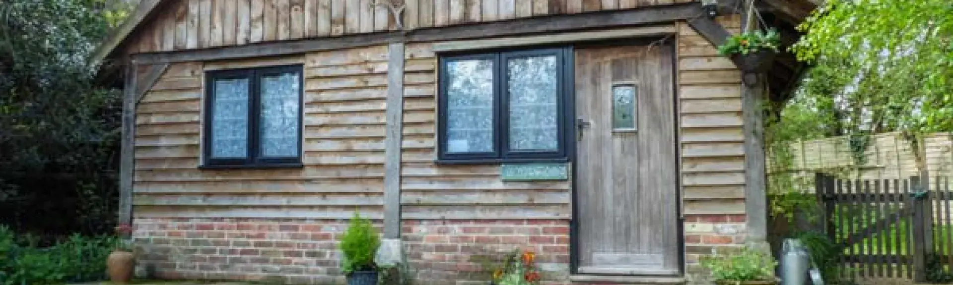 Exterior of a wooden eco-lodge near Ringwood backed by mature trees.