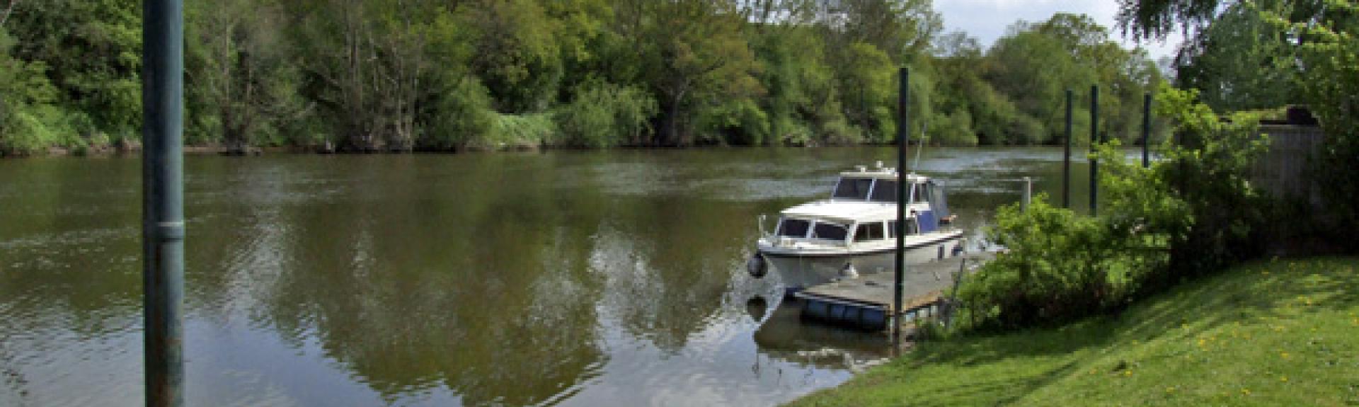 A lawn slope down boat moored on the banks of the River Severn