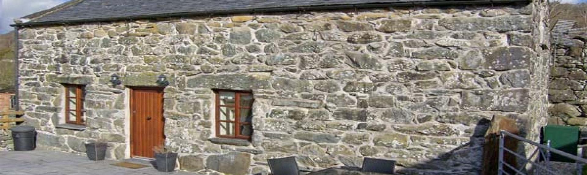 A long, stone-built, single storey, courtyard barn conversion in Gwynedd