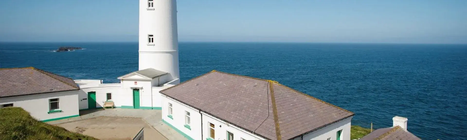 A Lighthouse complex on a clifftop with panoramic ocean views.