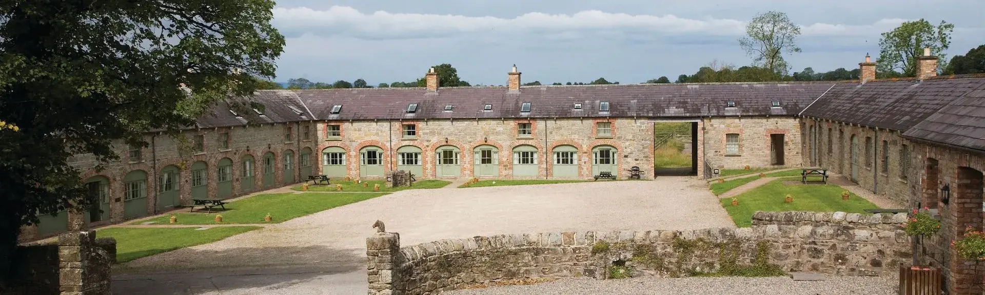 Two rows of cottages converted from stables line two-sides of a courtyard.