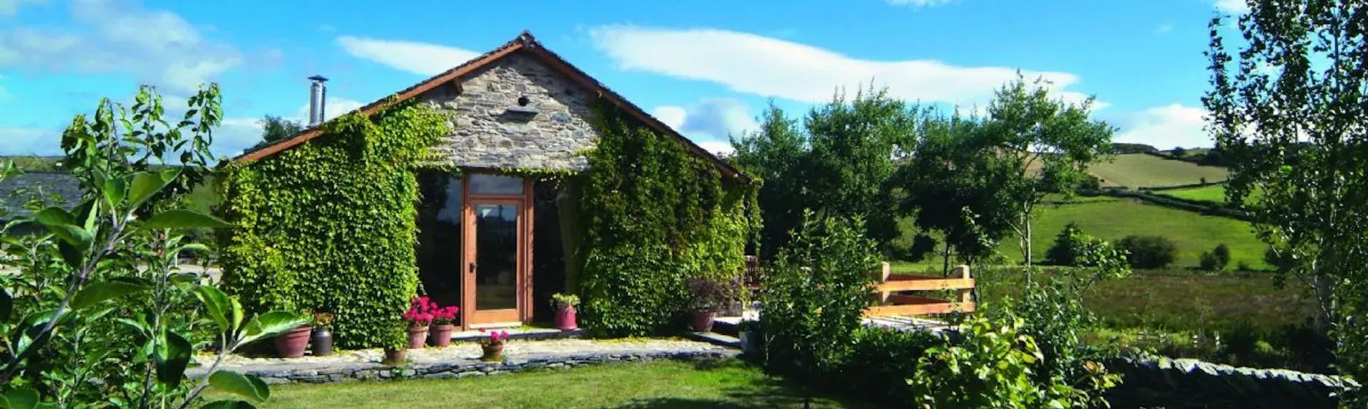 The Gable end of a single-storey barn conversion overlooks a country garden.