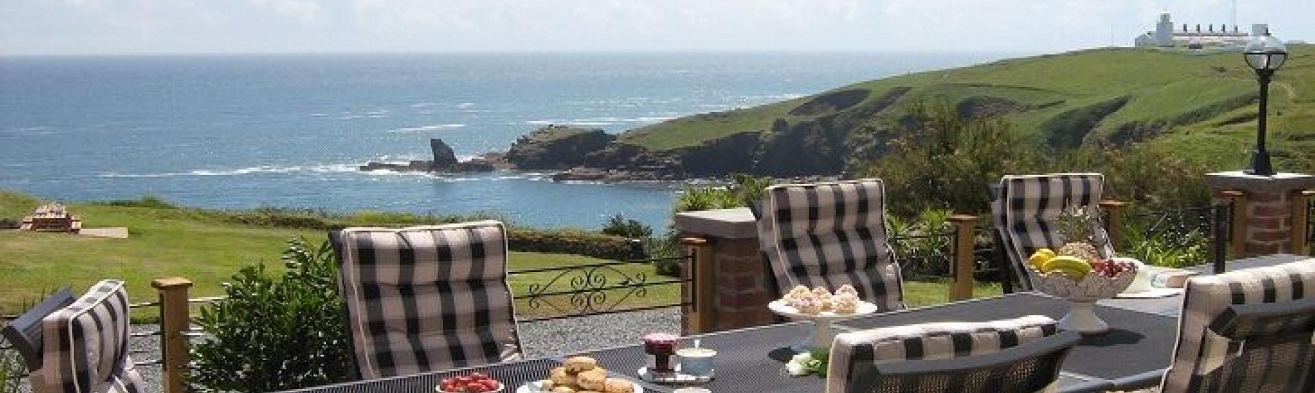 Chairs around an outdoor dining table offer beautiful sea views.