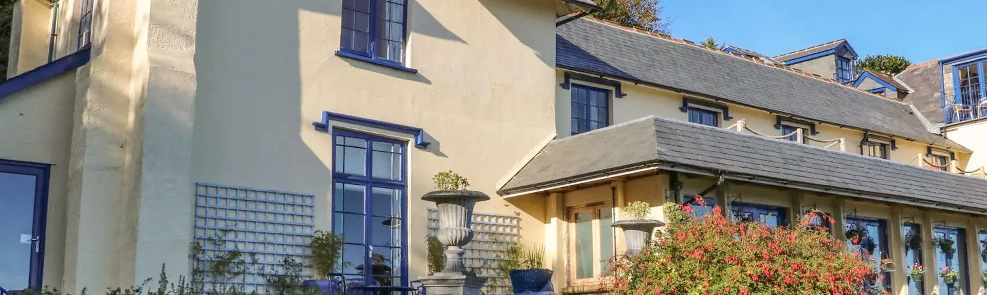 A 2-storey Lynton apartment building overlooks a shrub-filled front garden