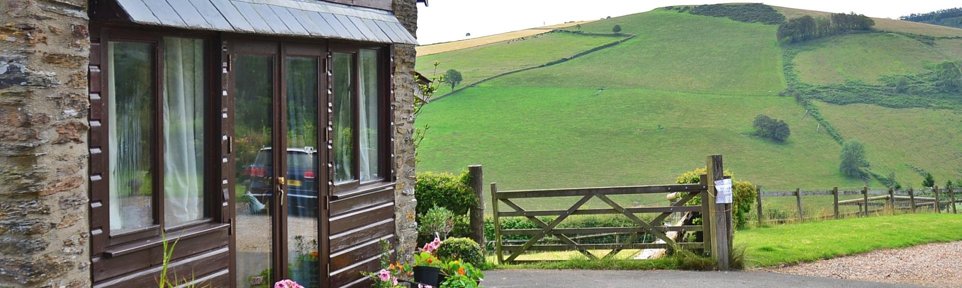 The gable-end of a country cottage surrounded by Exmoor's rolling hills.