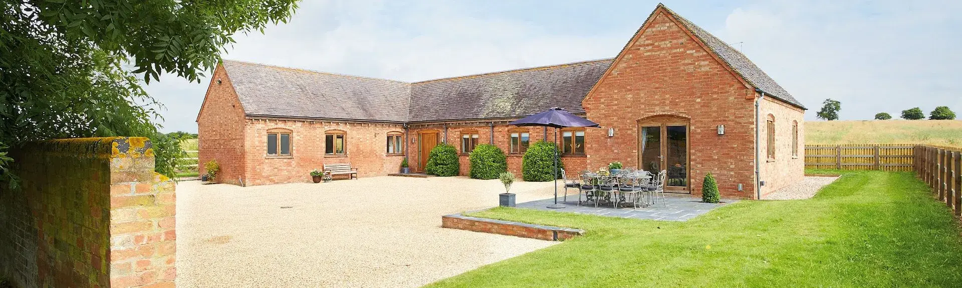 A large C-shaped single-storey rural cottage built around a courtyard.