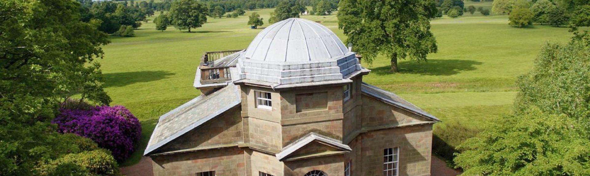 A converted Victorian folly stuled like a temple is surrounded by open parkland.