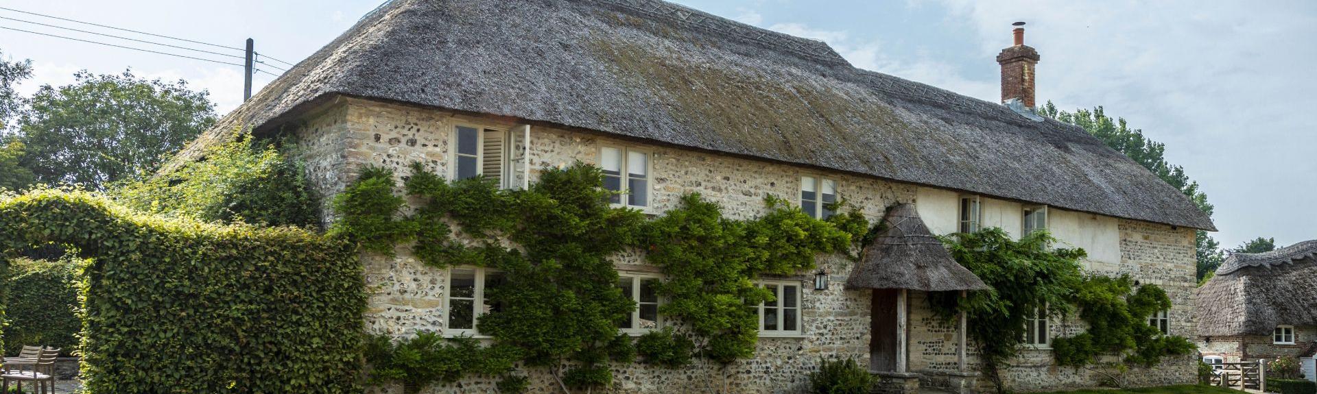Large, thatched Dorset Farmhouse overlooking a courtyard.