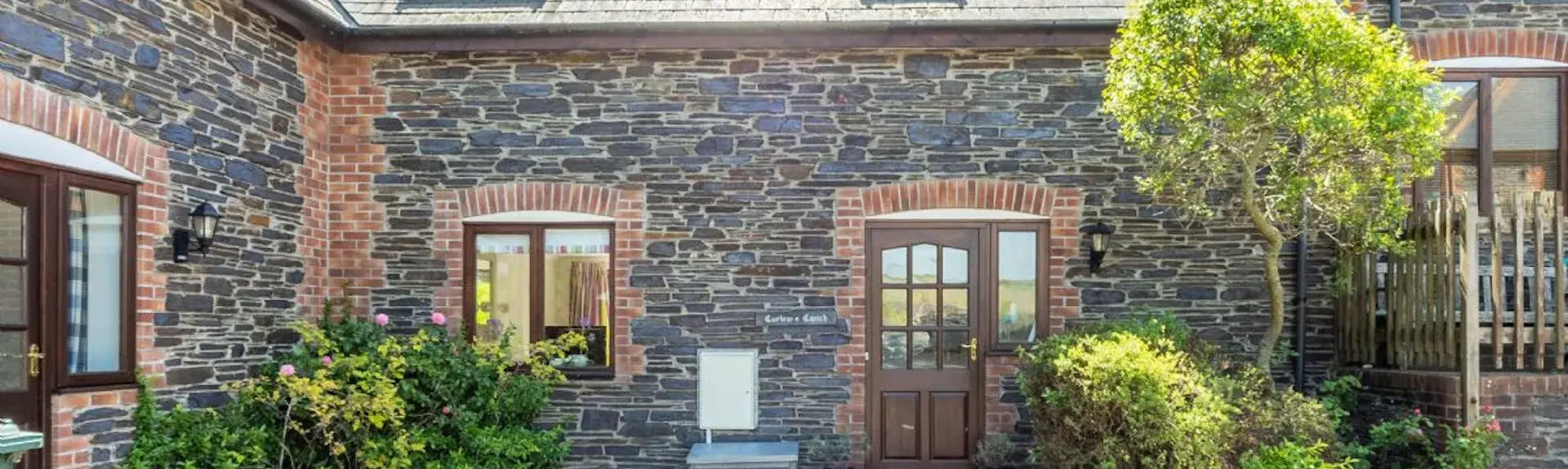 A semi-detached Cornish cottage overlooks a block-paved courtyard.