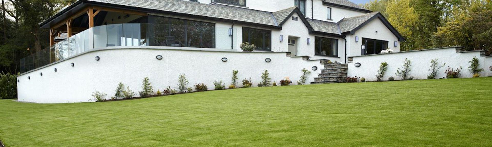 Large Windermere holiday cottage on a terrace overlooking a spacious lawn.