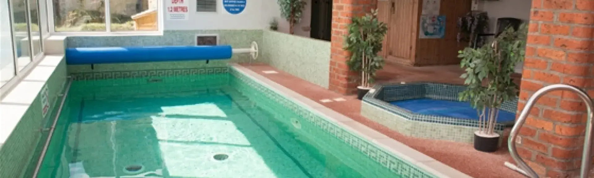 A heated indoor swimming pool with a hot tub.