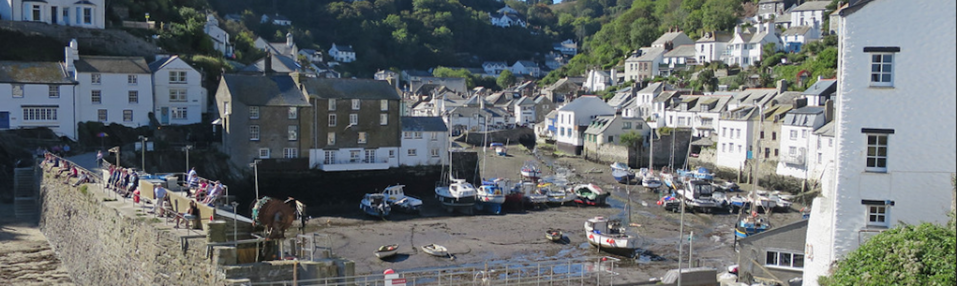 Fishermen's cottages line the quayside of Polperro harbour at low tide