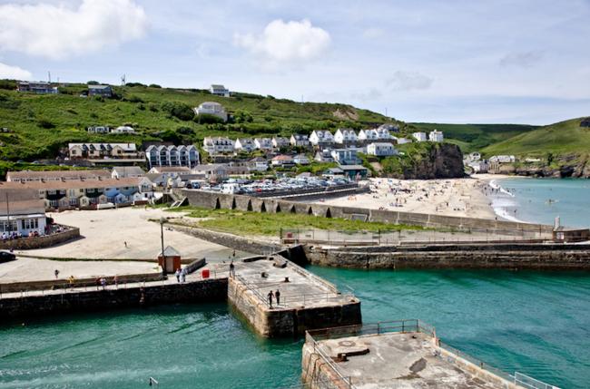 A view of the Harbour at Portreath with the beach and village beyond.