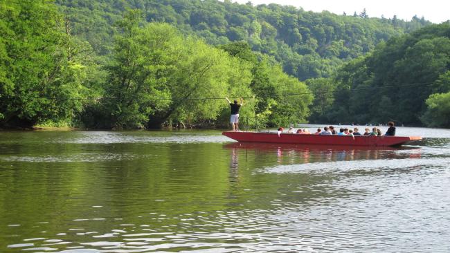 Enjoy Riverside Cottage Holidays in Symonds Yat A long punt operating as a ferry crosses the wide River Wye surrounded by tree-lined banks