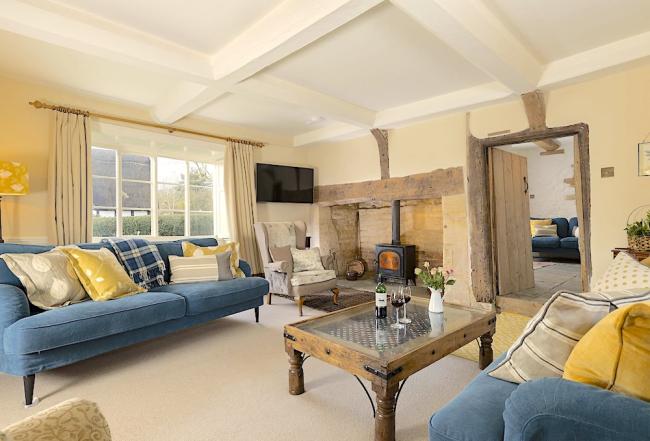 The lounge at Manor Farm. A large holiday cottage near Tewkesbury A lounge with oak beams, inglenook, cosy sofas and coffee table.