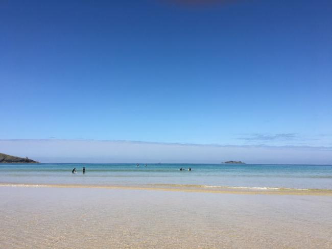 The Beach at Harlyn Bay in Cornwall. A Cornish sandy beach at low tide beneath a clear summer sky.