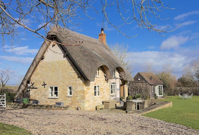 Book village holiday cottages in Elmley Castle. Photo credit: Field Cottage A thatched cottage overlooks a village green.