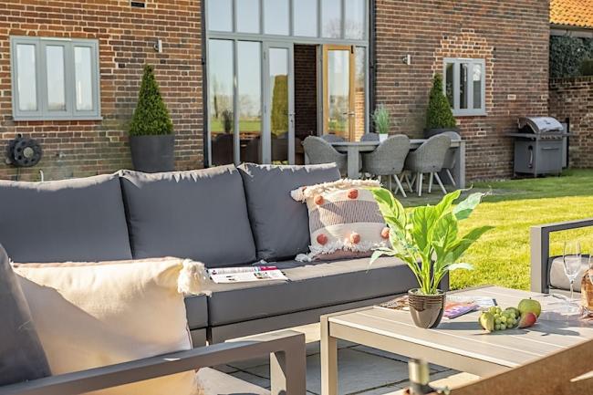 Burlingham Green Holiday Cottages An outdoor sofa, chairs and table on a terrace outside a house