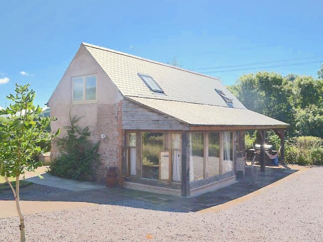 Discover holiday cottages that welcome and cater for children. Photo credit: Beer Farm in Somerset. A stone country cottage with a large sun room and a hammock on its deck.