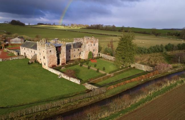 View Holiday Cottages in Laithes A partially restored country manor house surrounded by open fields.