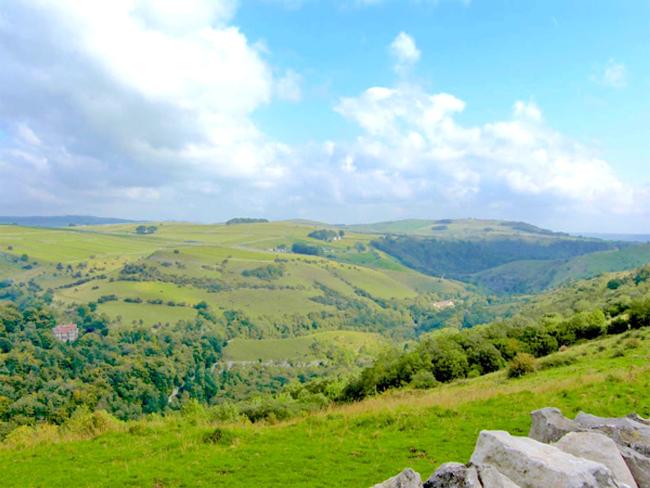 View Priestcliffe Holiday Cottages A large Peak District valley with fields and trees toped by moorland