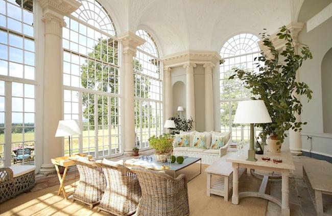 Luxury Holiday Homes in Shifnal . Photo credit: Temple of Diana A luxuriously furnished, tall-windowed orangery with table and whicker chairs.