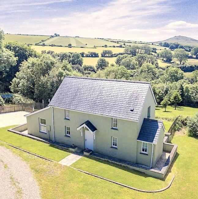 Plas Drygarn, A Remote Cottage in Pembrokeshire's Preseli Hills. A remote holiday cottage in an isolated rural location surrounded by trees and fields.